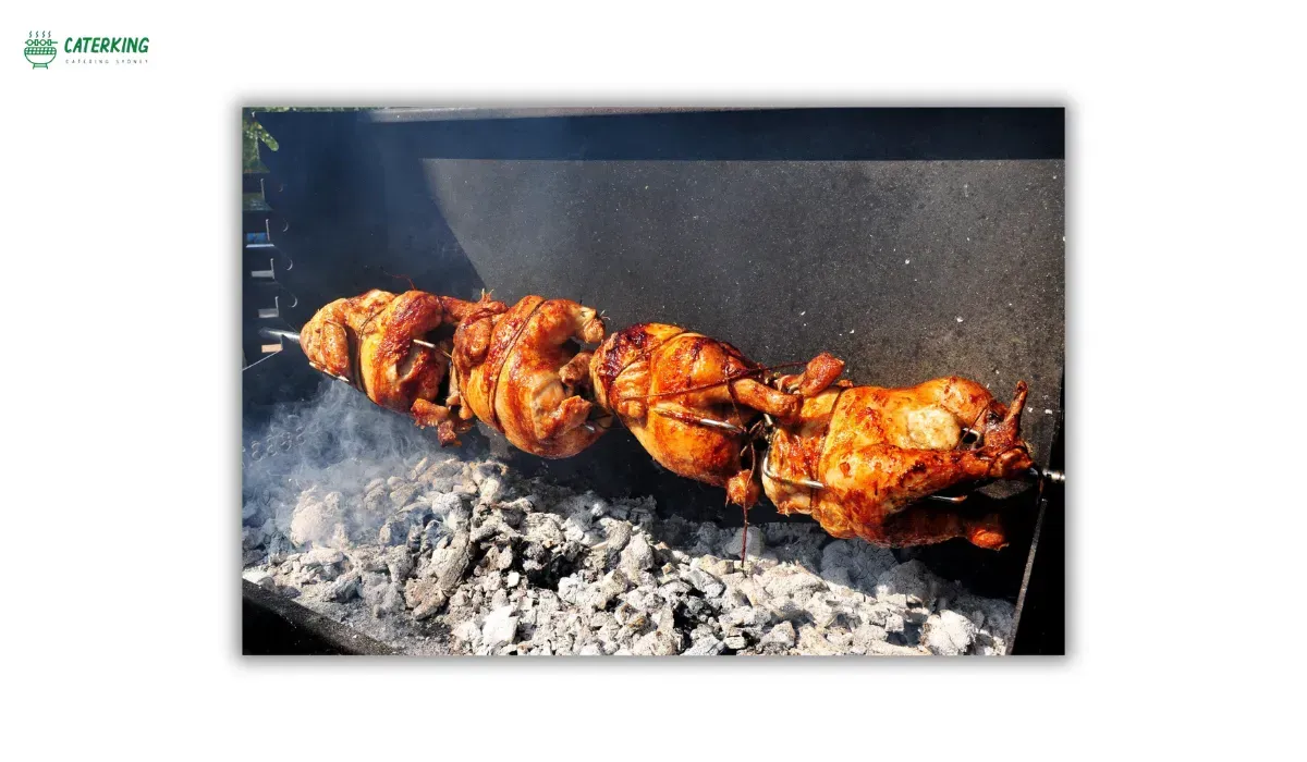 BBQ rotisserie cooking chicken evenly over indirect heat