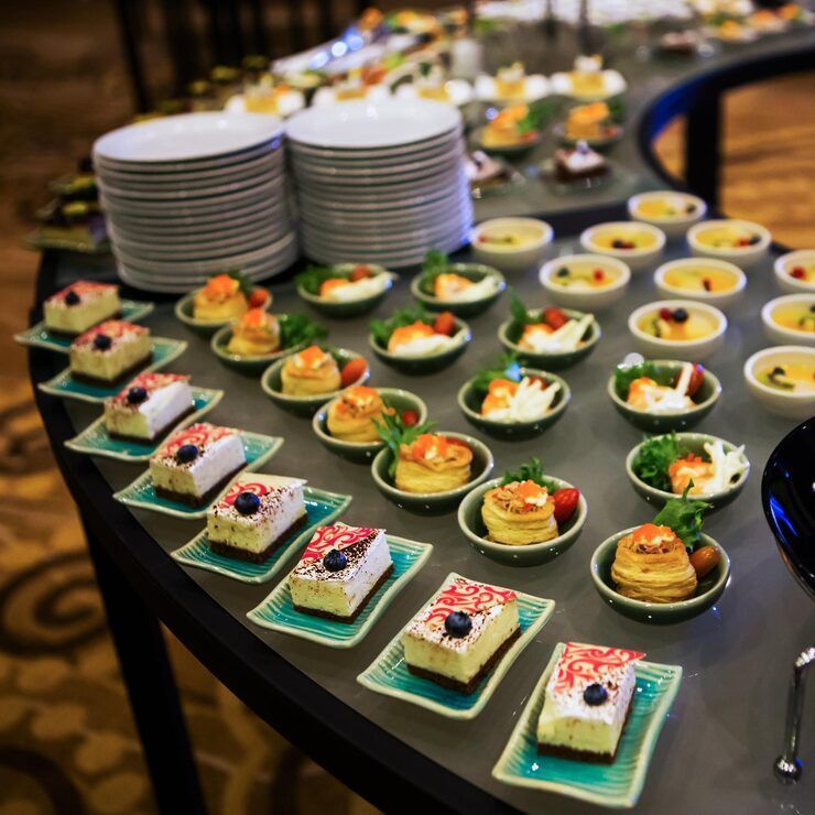 A table laden with plates of salad, fruit, and other appetizers for a gathering.