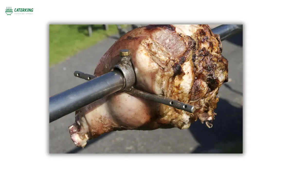 small jumbuck spit roaster cooking pork shoulder and lamb leg for backyard gathering
