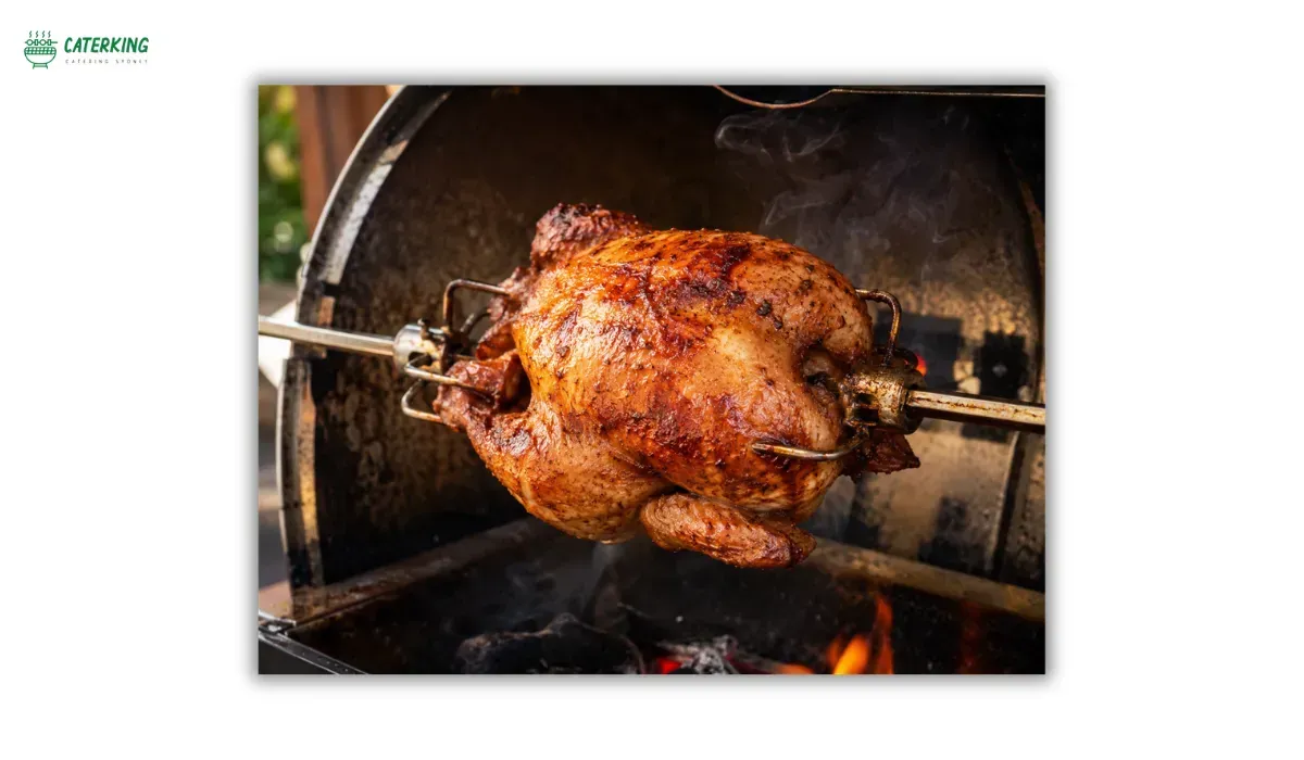 whole chicken roasting on a BBQ rotisserie with crispy golden skin