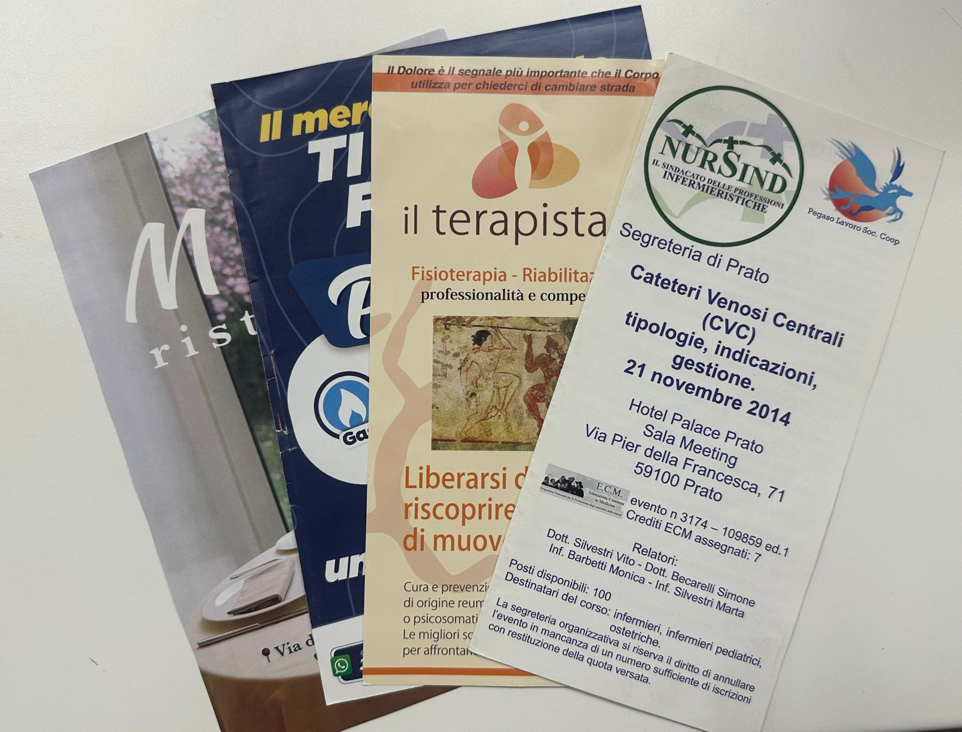 Volantini impilati, con testo e grafica. I titoli includono i dettagli dell'evento