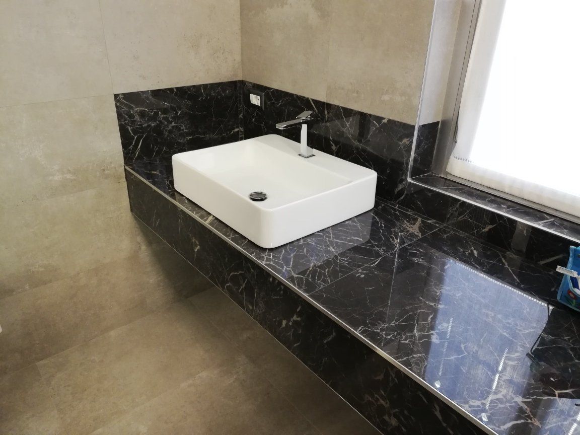 lavabo bianco su piano in marmo nero
