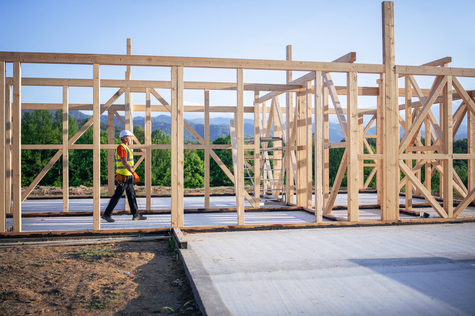 A Builder Working on a Wooden House in Nature, Walking in Construction Frame | Brisbane, Qld | Virginia Building Supplies A Builder Working on a Wooden House in Nature, Walking in Construction Frame | Brisbane, Qld | Virginia Building Supplies