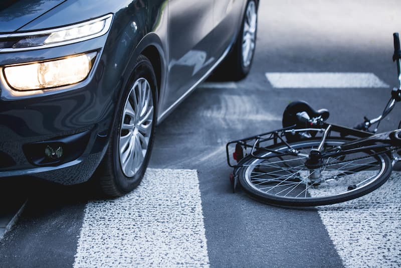 fallen bicycle next to  car