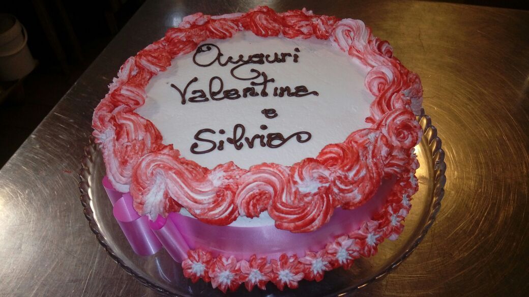 Torta con glassa rossa e bianca, scritta