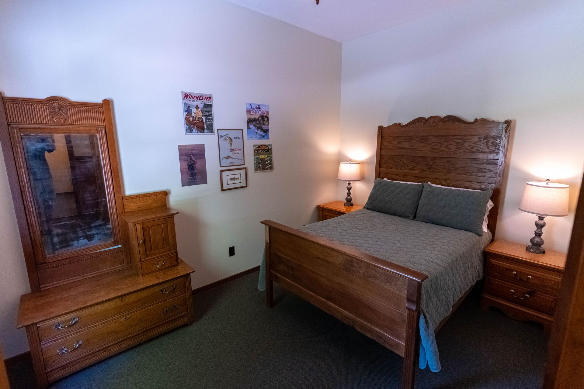 Cozy bedroom with wooden bed and dresser, two bedside lamps, and framed art on the wall