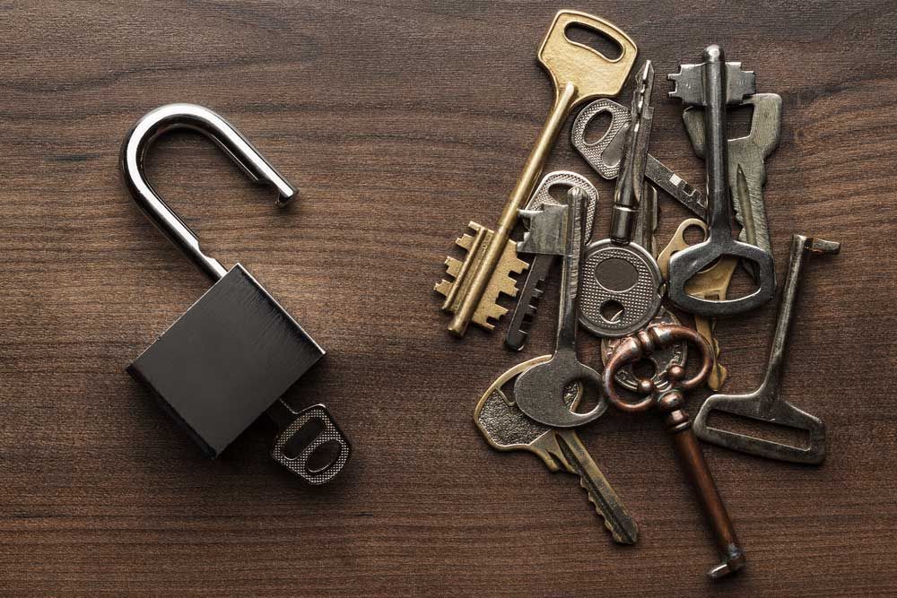 A bunch of keys and a padlock on a wooden table — Locksmith in Southport, QLD