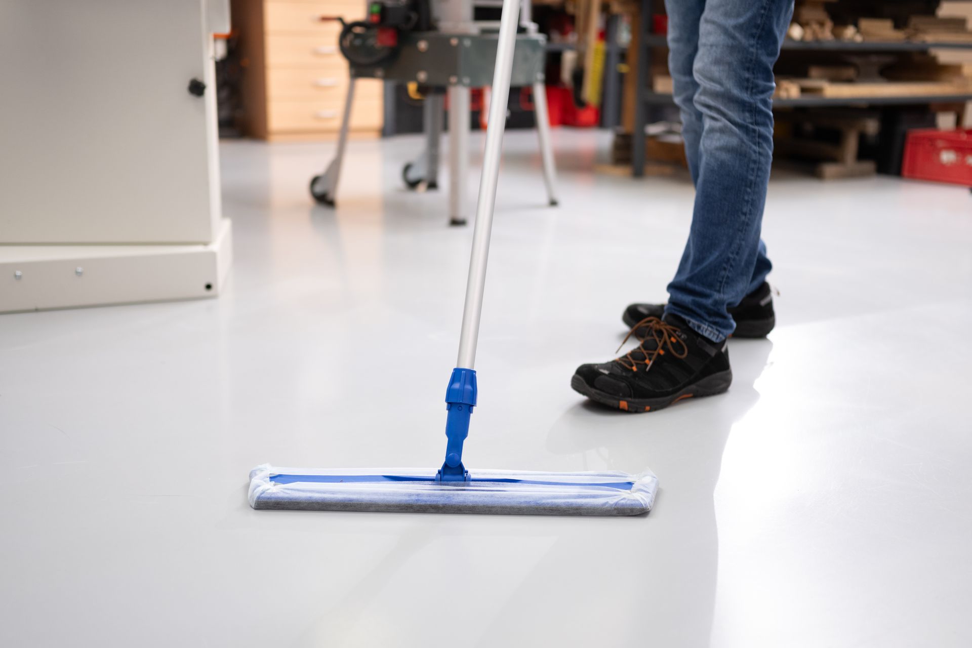 En person rengör golvet med en mopp.