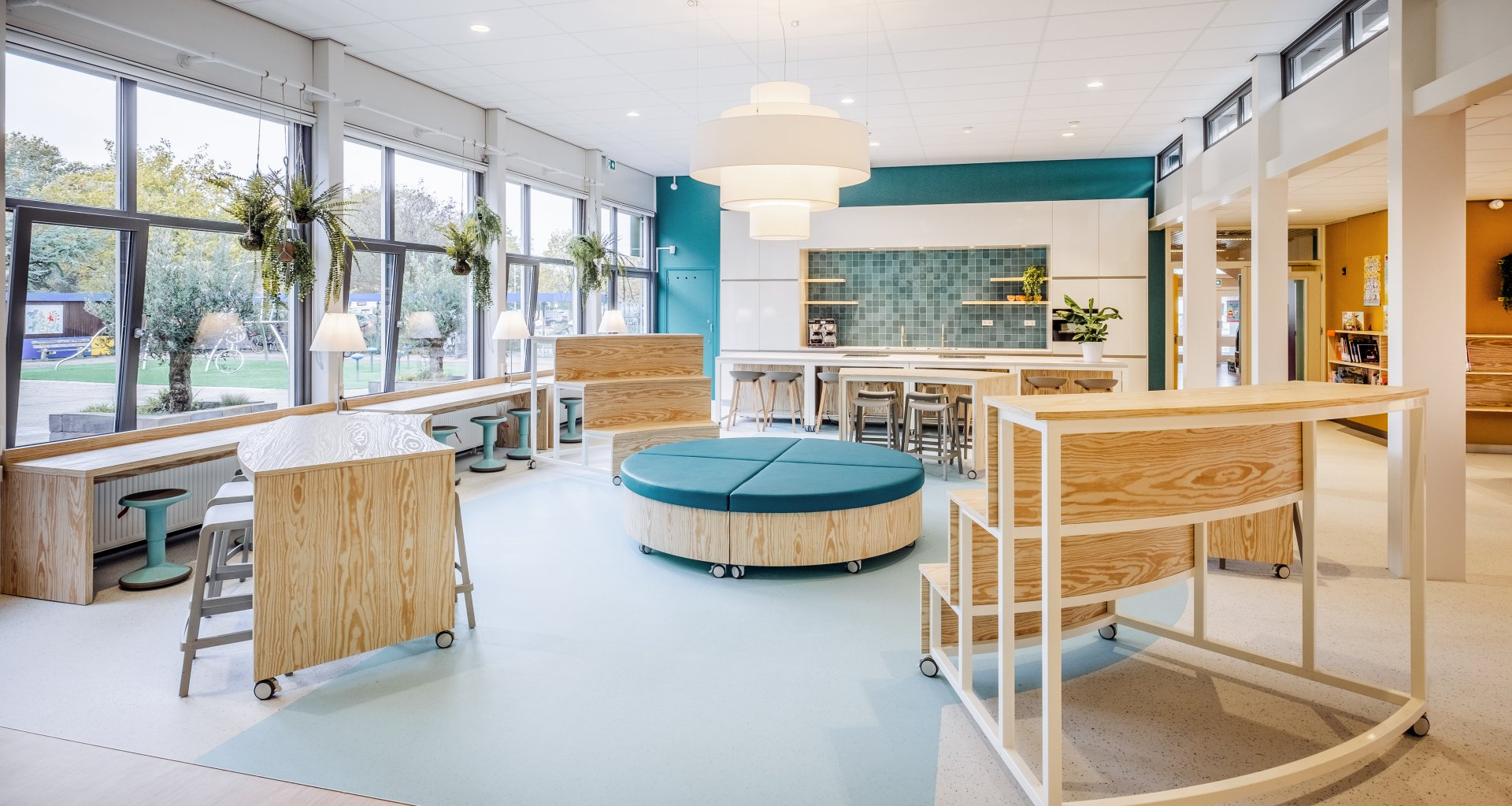 Het moderne kantoor van de The Future Group in Zoetermeer,met houten bureaus, stoelen, een rond vloerkleed en een plant tegen terracotta muren, interieurontwerp door KuóStudio