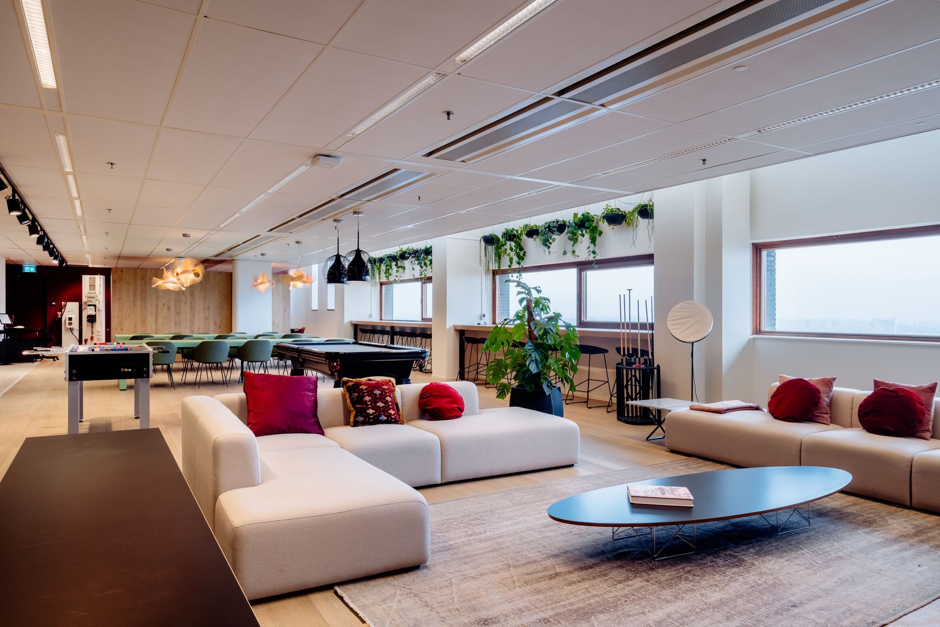 Een moderne, open kantooromgeving met modulaire banken met een pooltafel. Interieurontwerp KuóStudio van het kantoor Rotterdam Eneco eMobility
