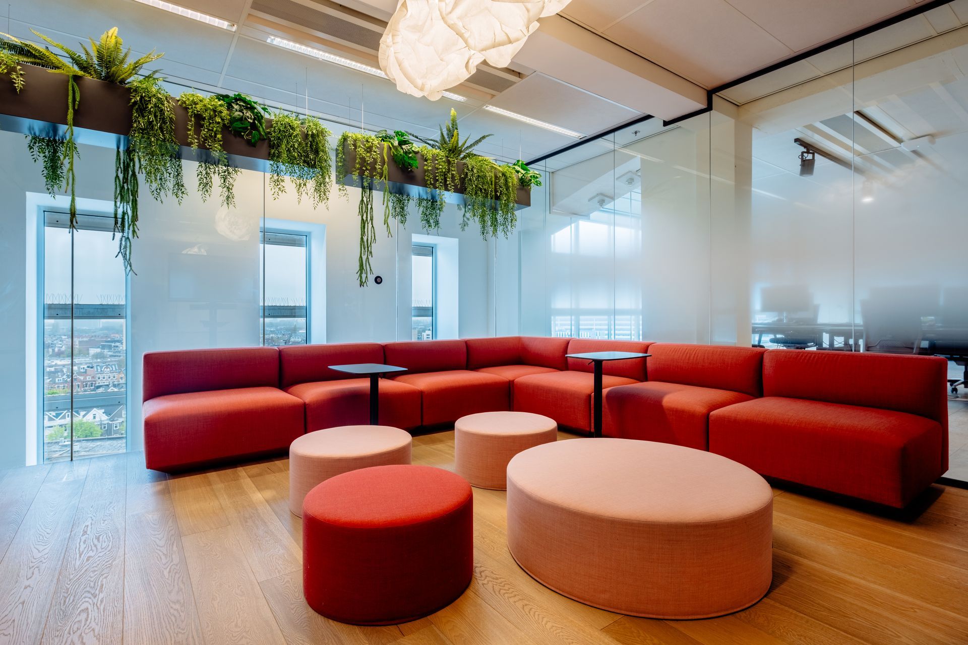 Een moderne kantoor met een hoekbank, en hangplanten, Interieurontwerp KuóStudio van het kantoor Rotterdam Eneco eMobility