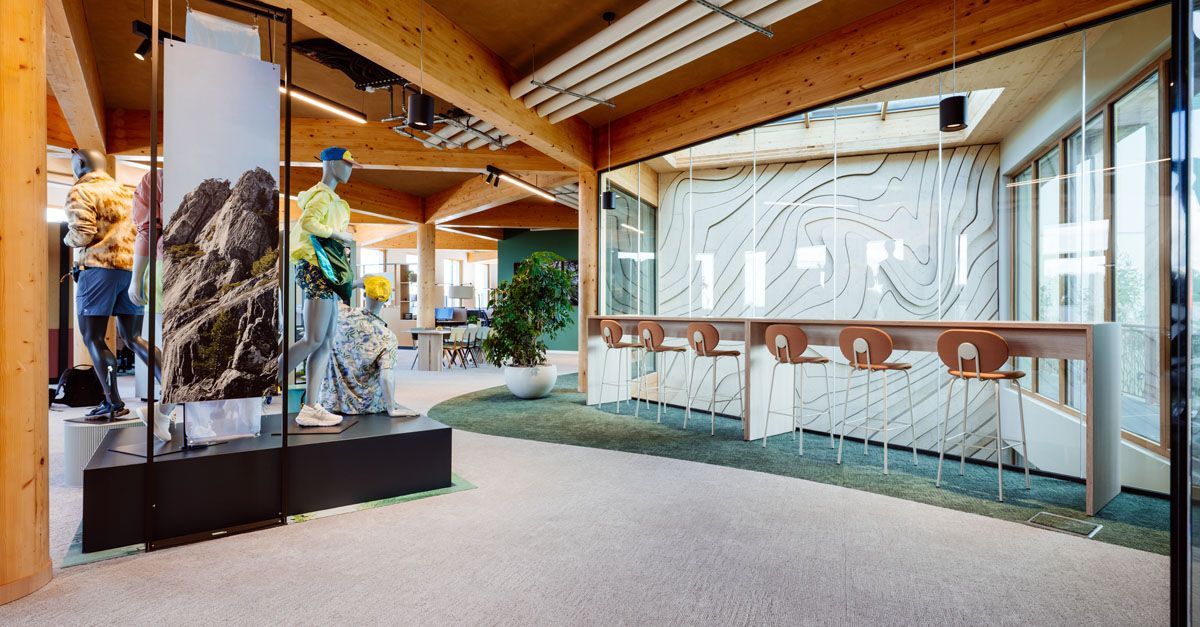 Modern lobby with wood beams, glass railing, and large landscape artwork. Biophilic Design
