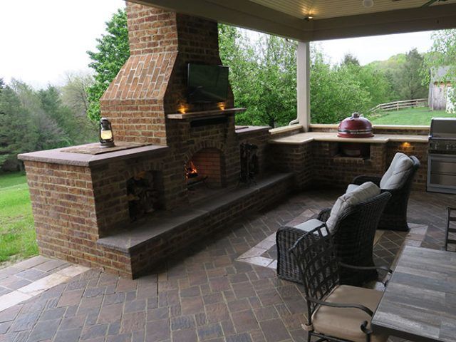 A patio with a brick fireplace and chairs A patio with a brick fireplace and chairs