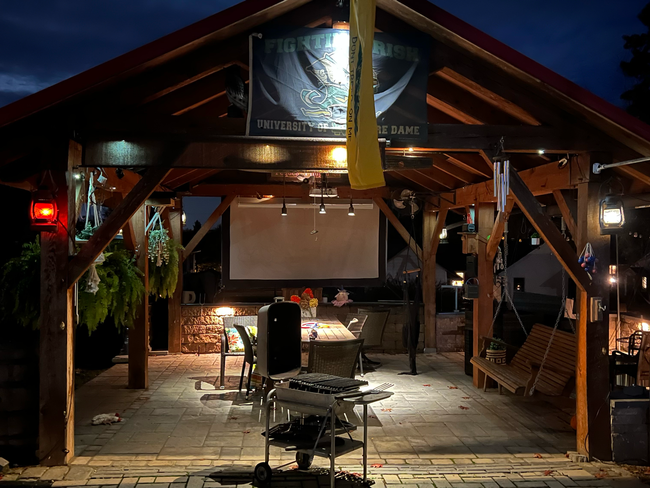 A patio with a brick fireplace and a grill A patio with a brick fireplace and a grill
