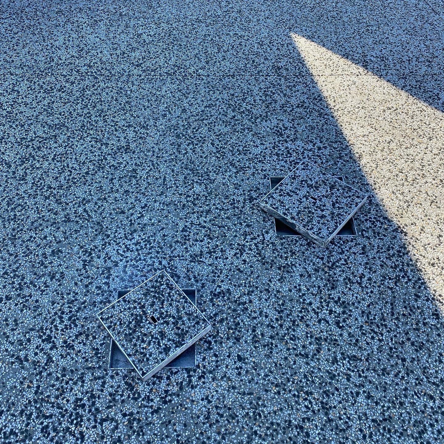 Exposed aggregate driveway with drain lids lifted up