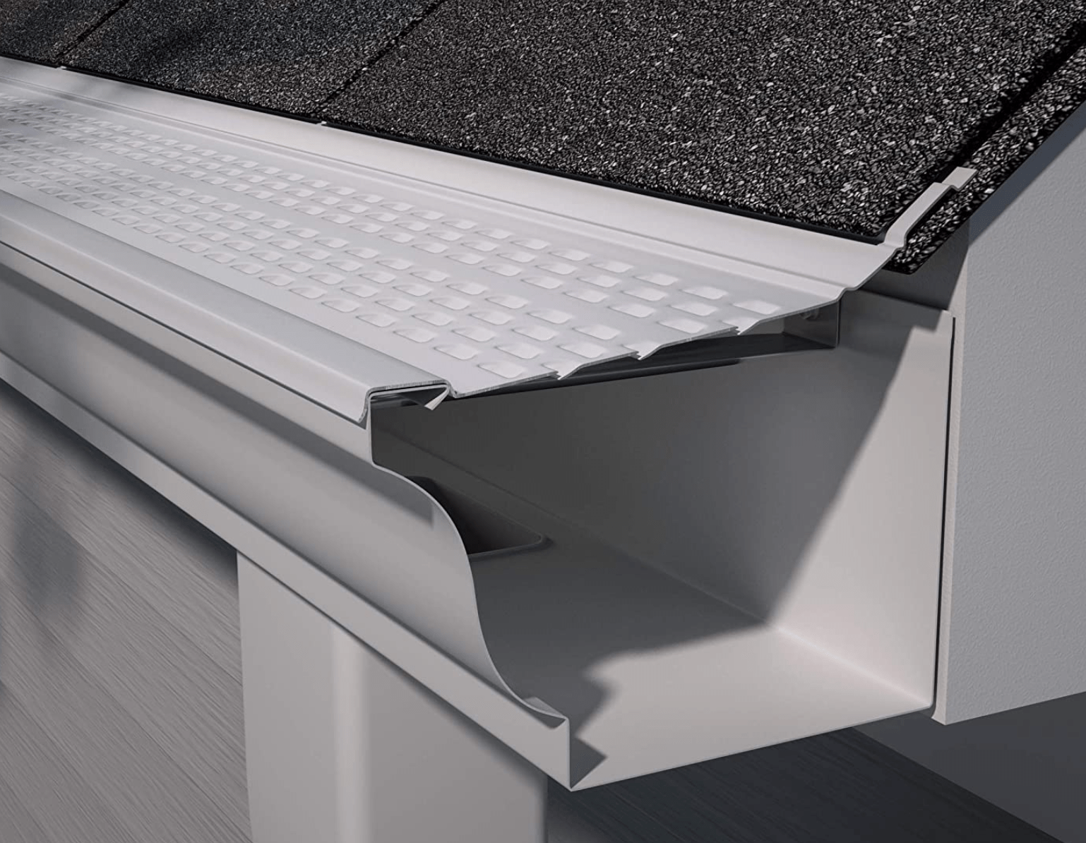 Close-up of a roof gutter and downspout with white trim under dark shingles.