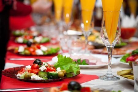 Elegant table setting with salads and orange drinks at a formal dinner party