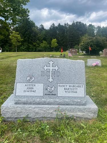 Gray granite tombstone with cross and names: Austin Jun, Nancy Margaret Rampant. Cemetery setting.