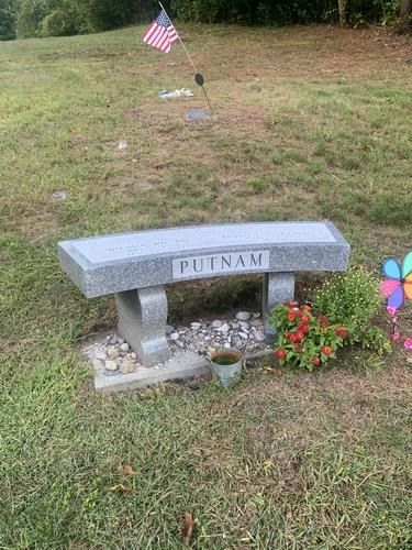 Grave site with a stone bench that reads 