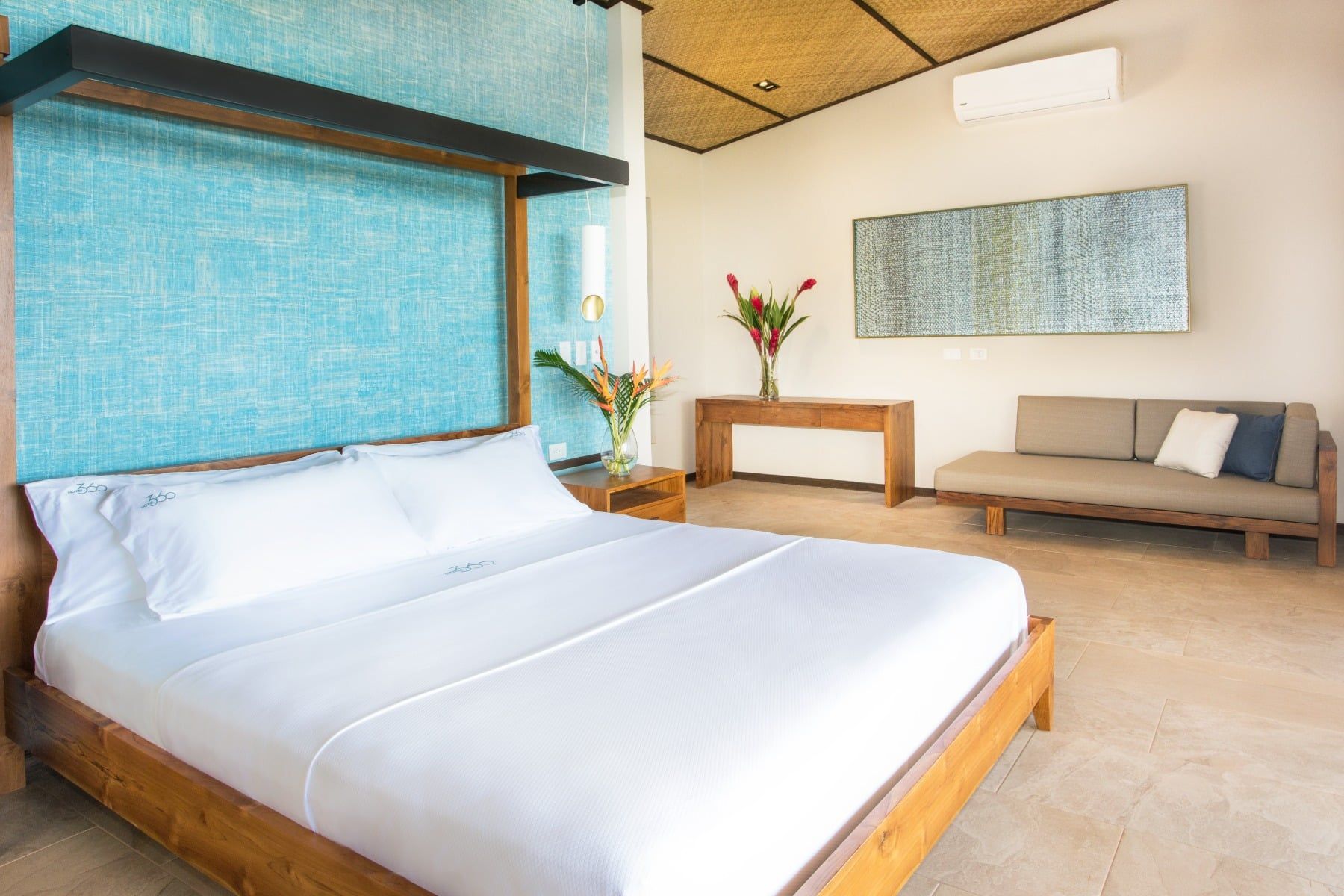 A hotel room with a king size bed and a couch.