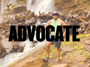 A man standing in front of a waterfall with the word advocate above him