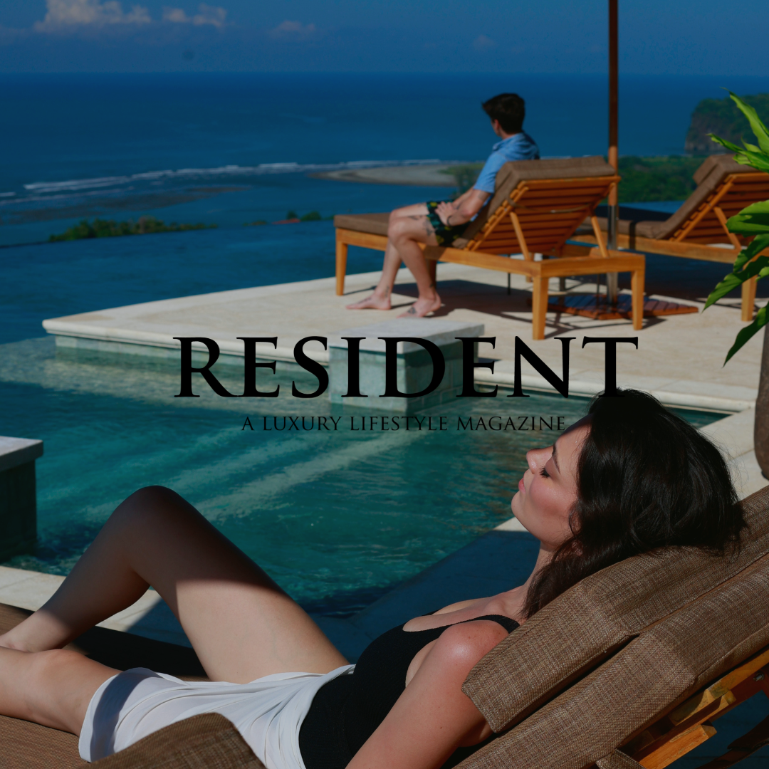 Woman sunbathing by infinity pool, man gazing at ocean; luxury vacation setting. 