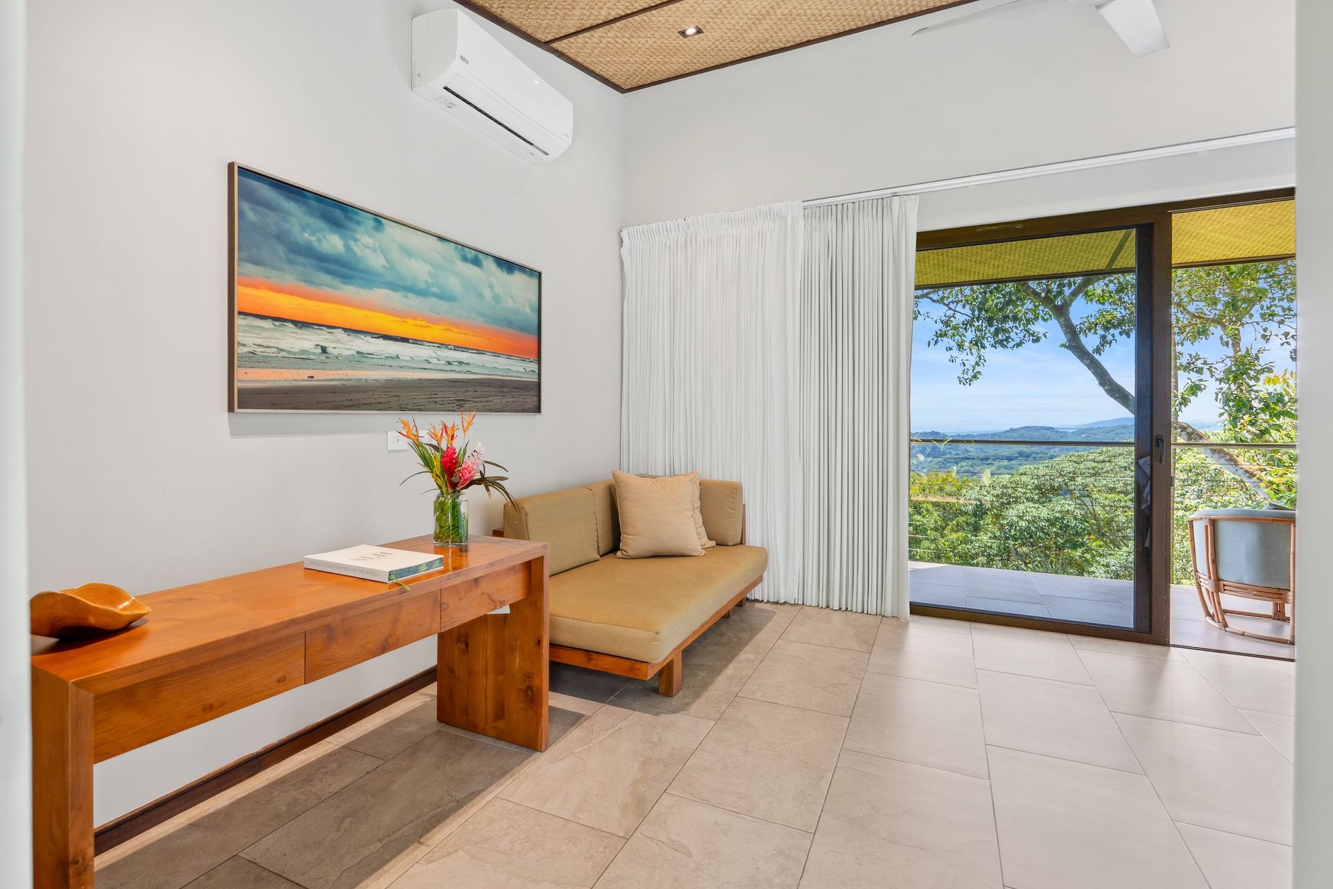 A living room with a couch , table , and a painting on the wall.