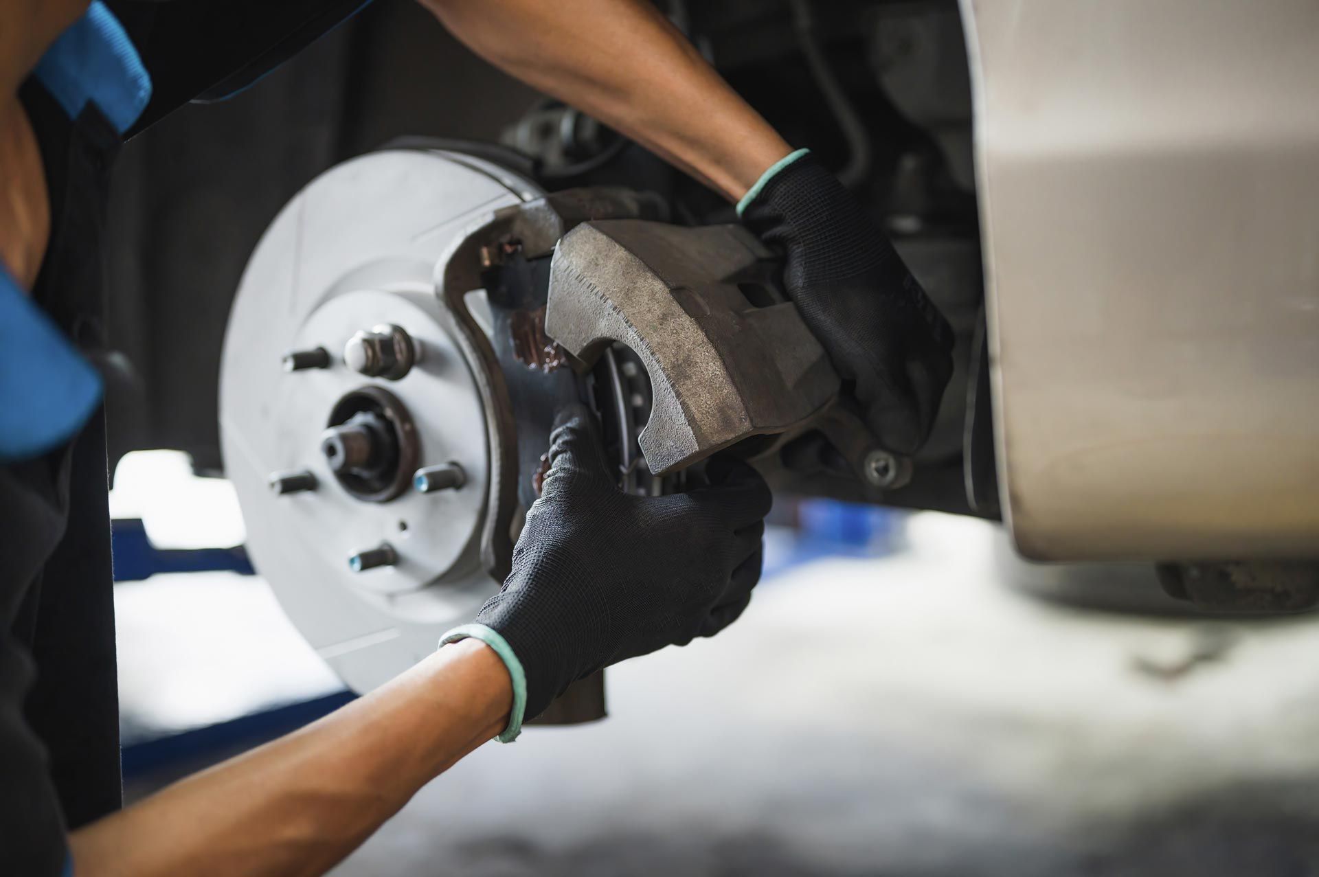 A mechanic is repairing a car’s brake. A mechanic is repairing a car’s brake.