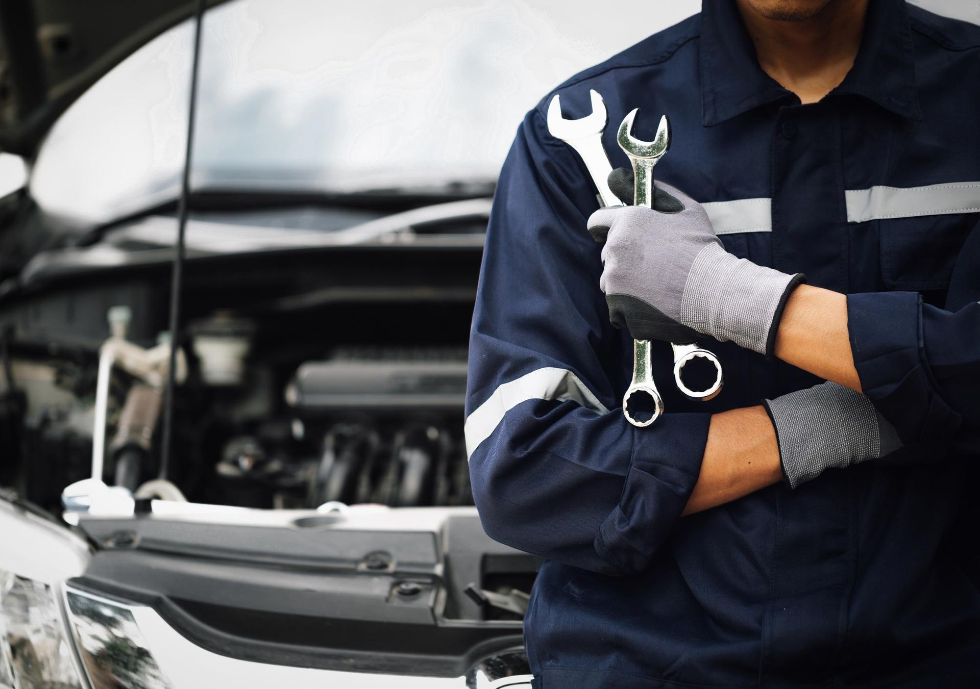 Man Holding Wrench In Front Of Car — O'Fallon, MO — O'Fallon Garage Man Holding Wrench In Front Of Car — O'Fallon, MO — O'Fallon Garage