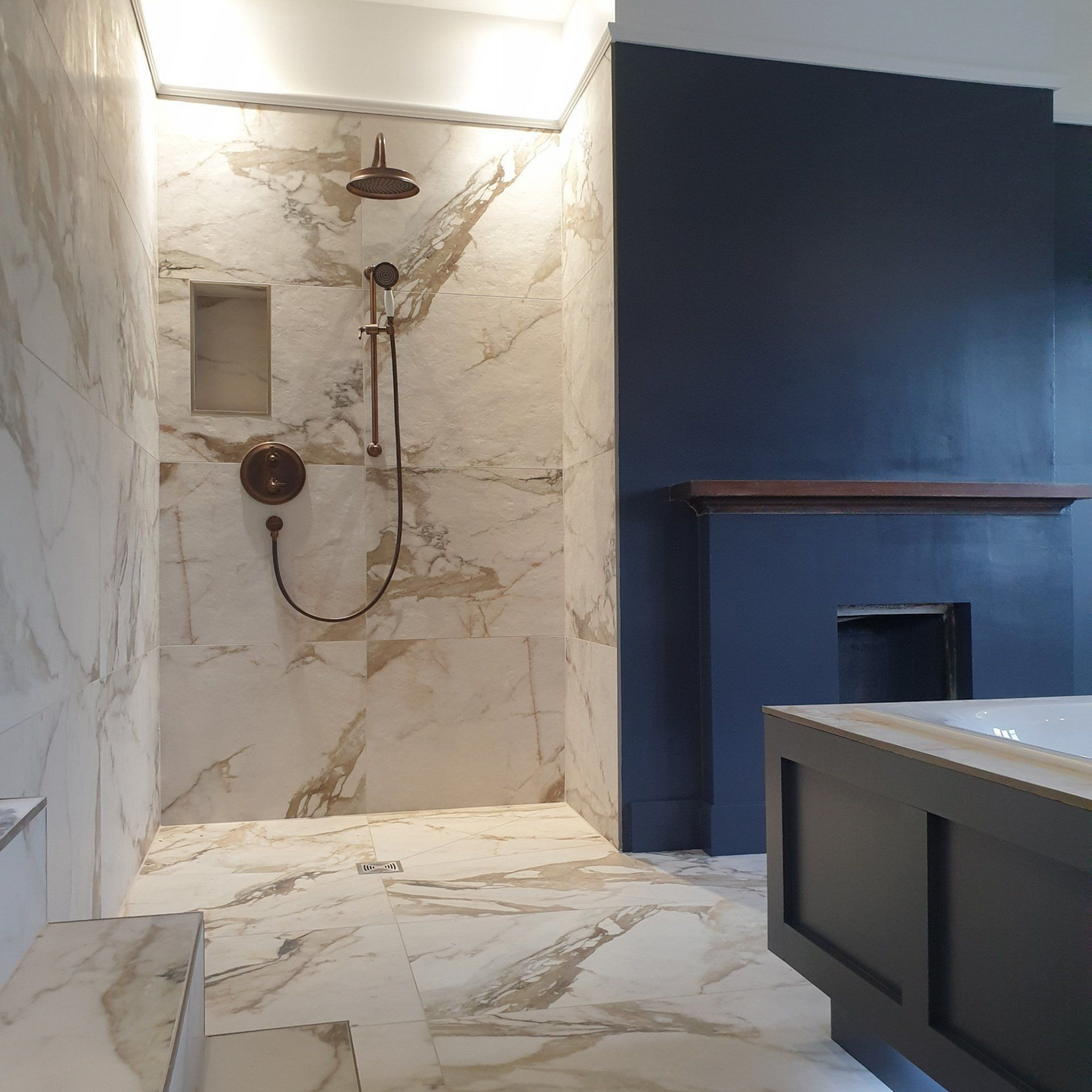Luxury walk-in shower installation with marble-effect wall tiles completed by bathroom fitters in Derby