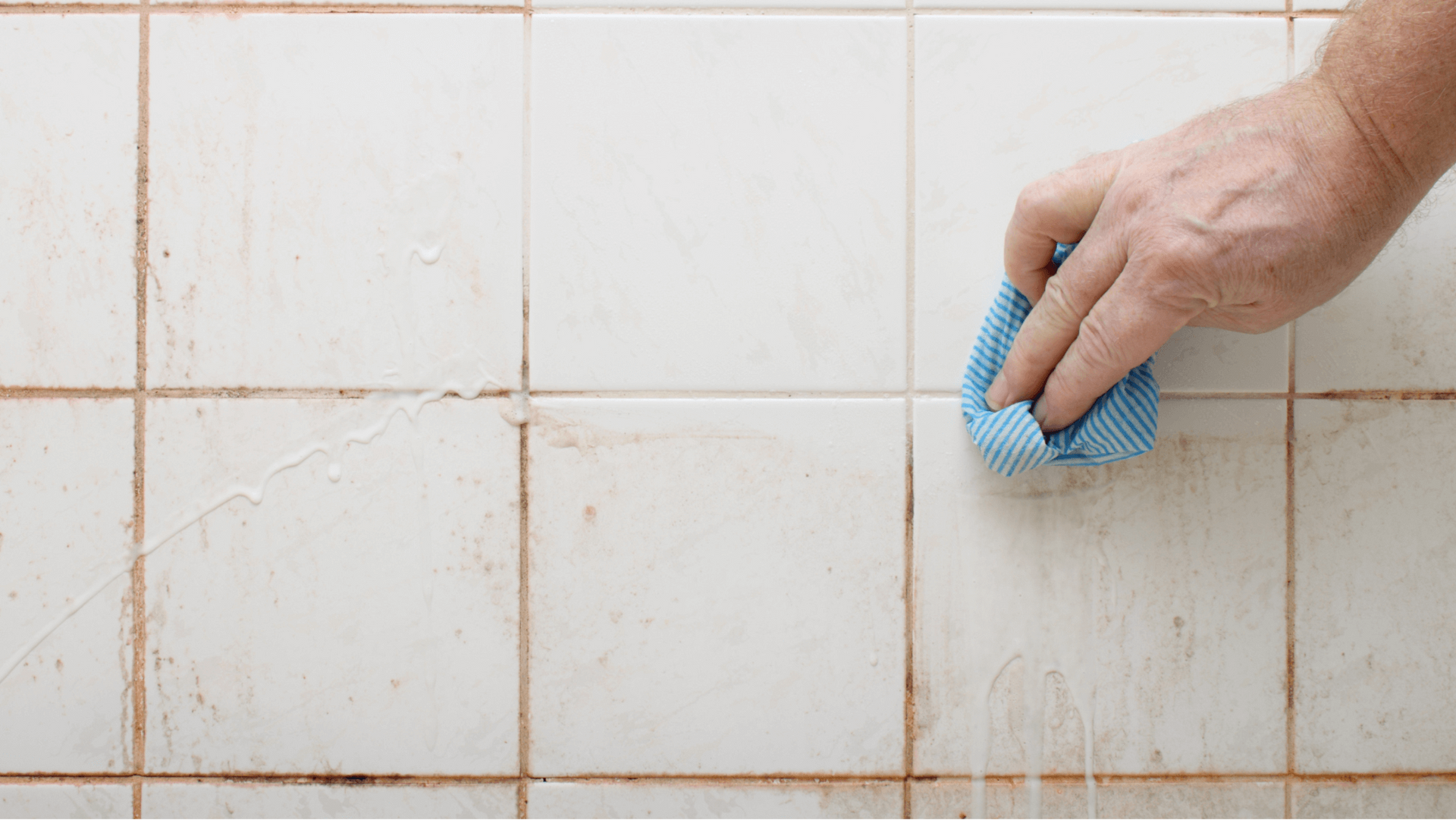 Man cleaning seal mould between tiles