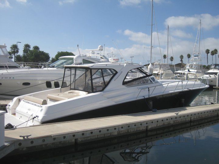 A large white boat is docked at a marina