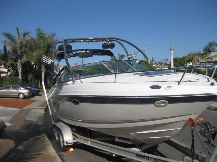 A boat is parked on a trailer in a parking lot