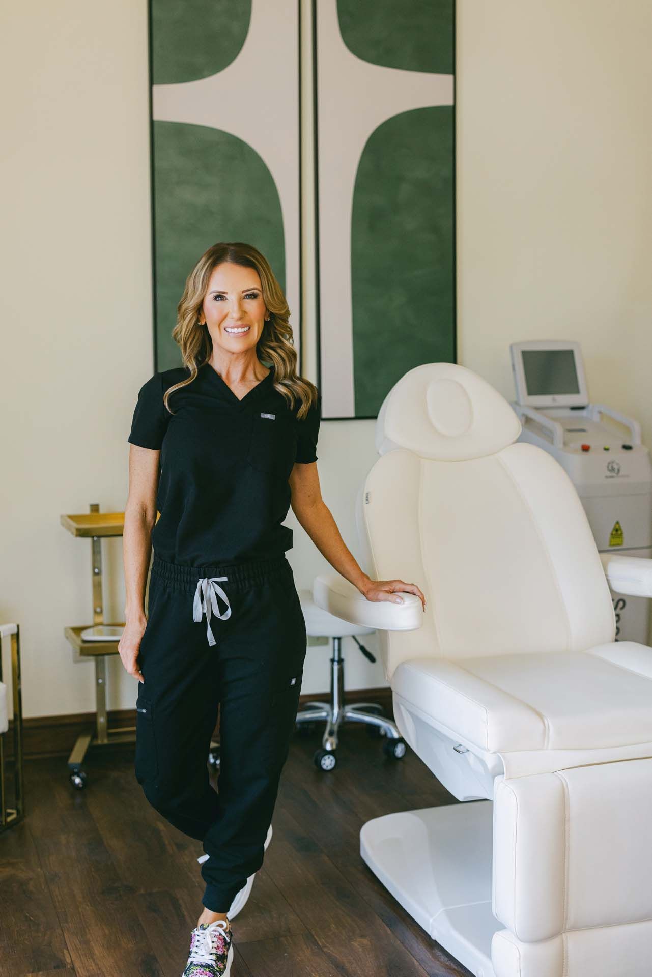 Person standing beside a white treatment chair in a clinic room