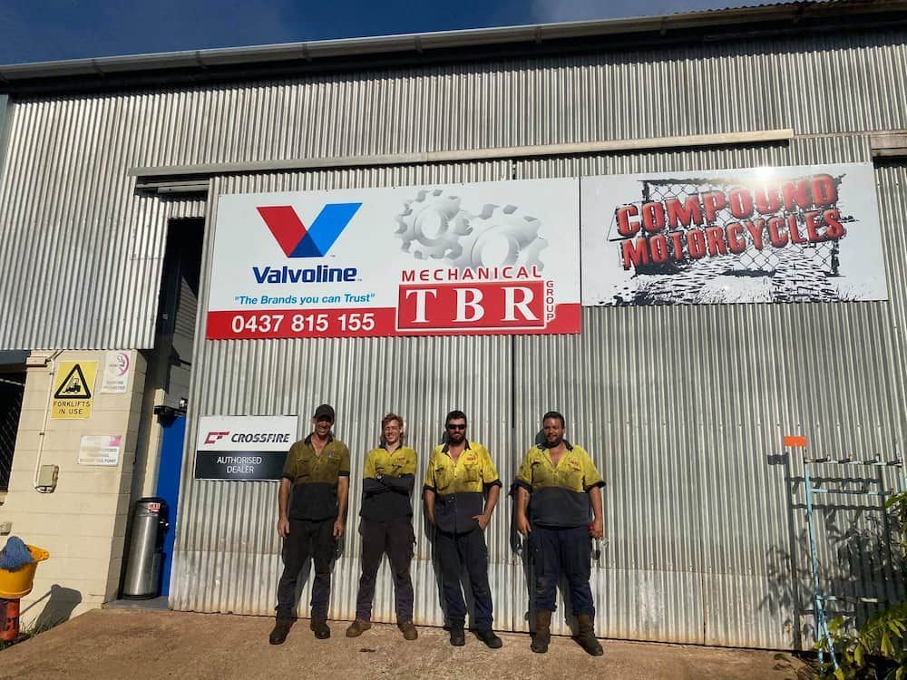 A Group Of Men Are Standing In Front Of A Building — TBR Mechanical in East Arm, NT