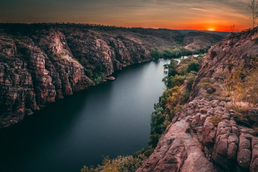A River Flowing Through A Valley Surrounded By Rocks At Sunset — TBR Mechanical in Katherine, NT