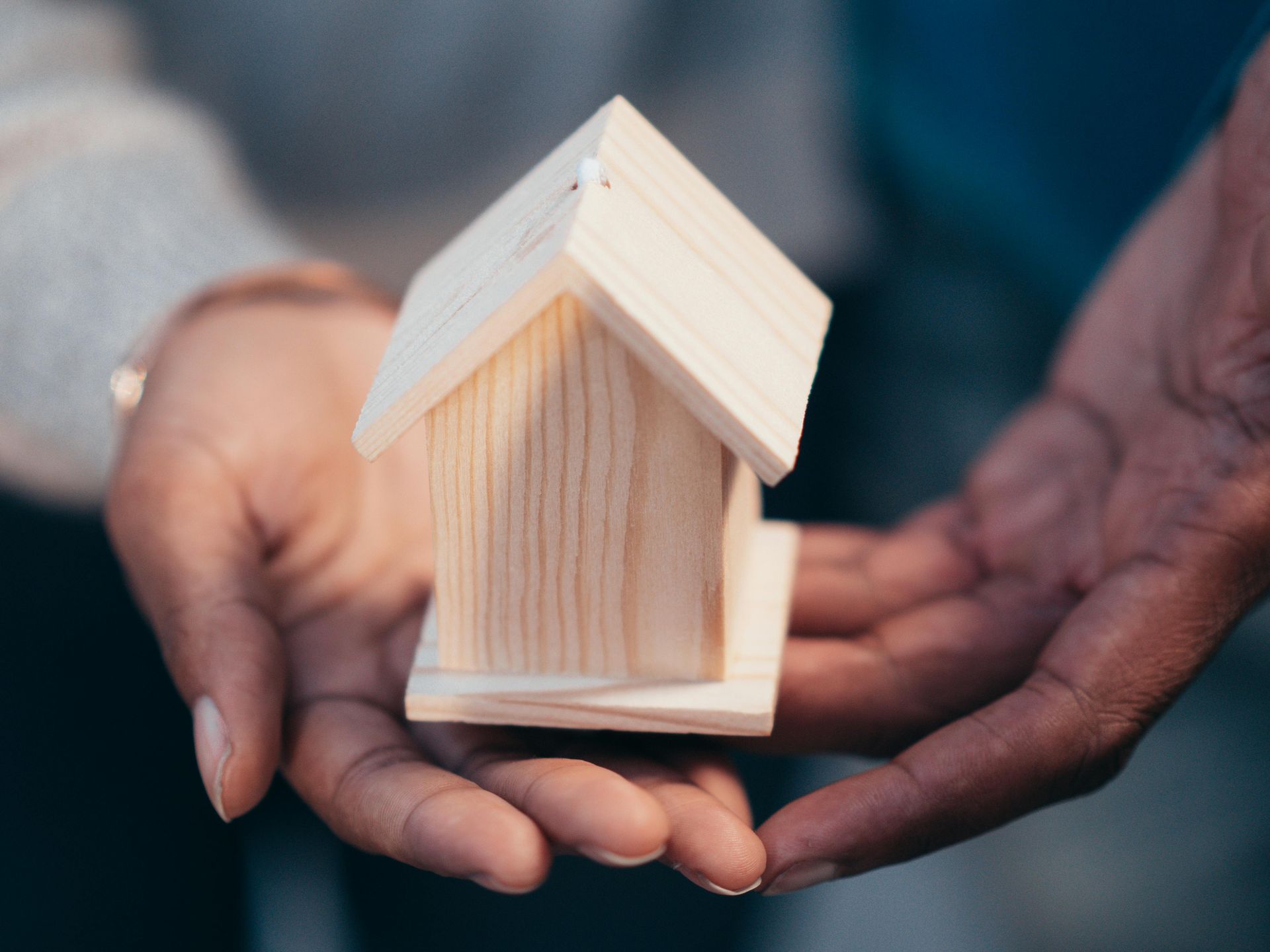 Tiny model house being presented as a symbol of house insurance