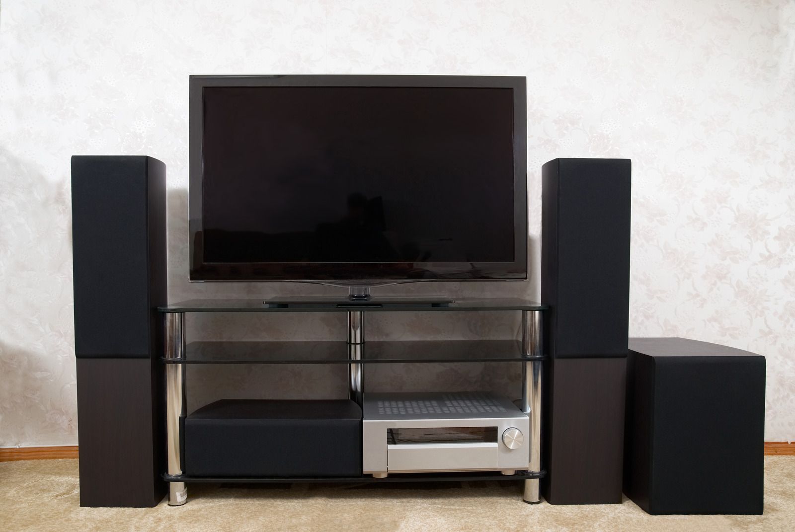 A flat screen tv is on a stand next to speakers