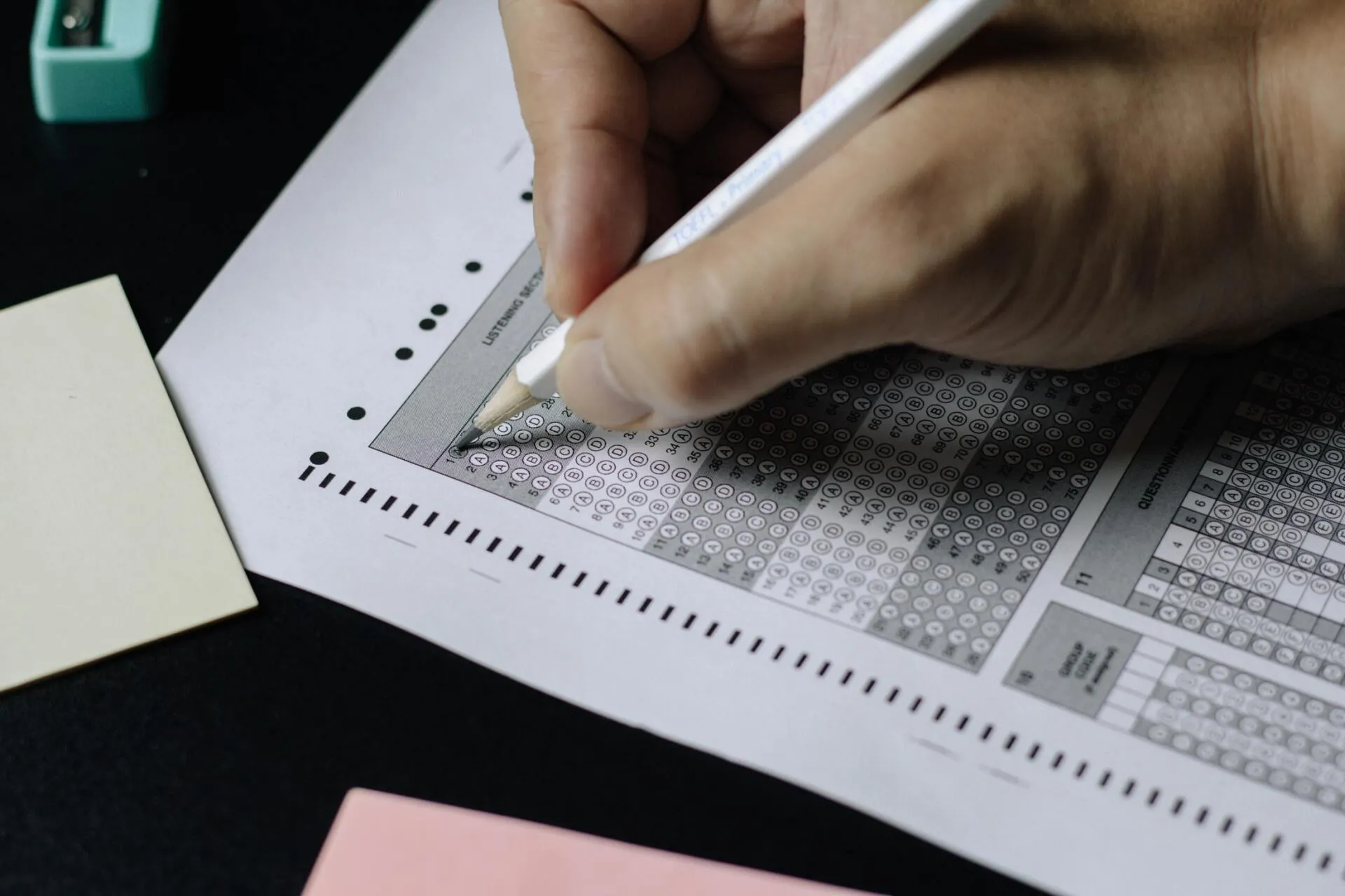 Image of a student filling in an exam response sheet