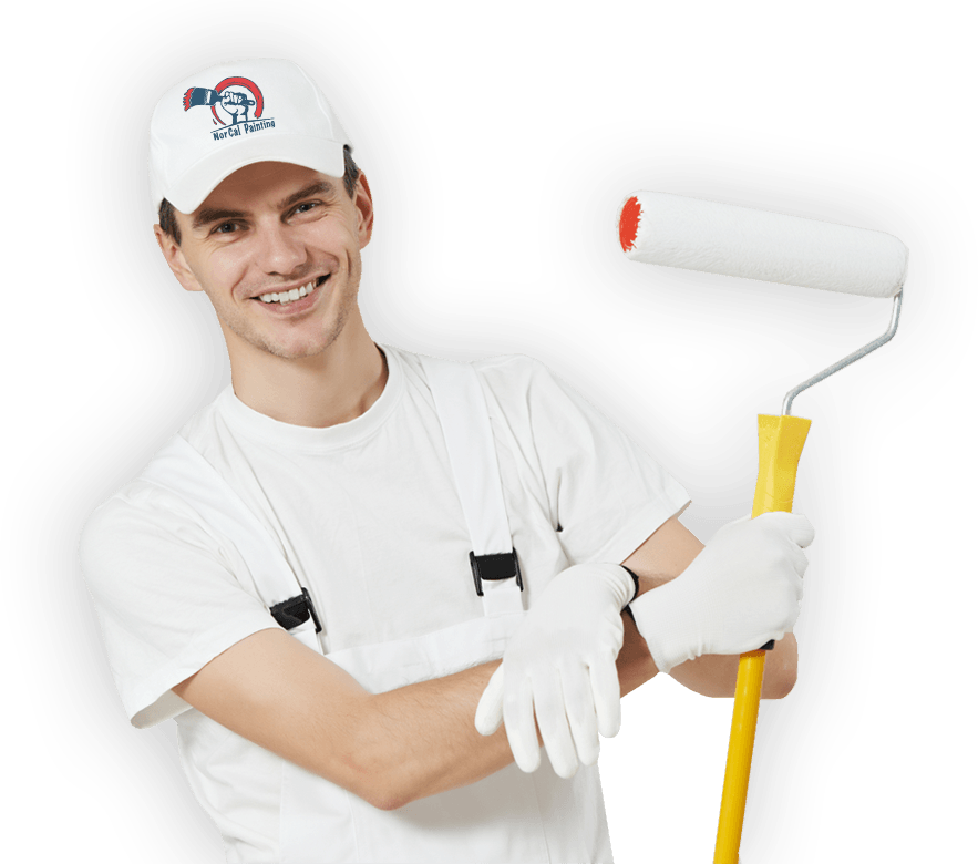A man is holding a paint roller and smiling for the camera