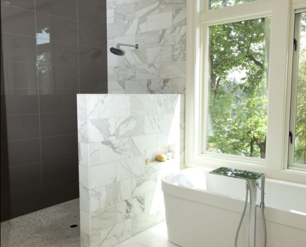 A bathtub with a shower head and towels on the side.