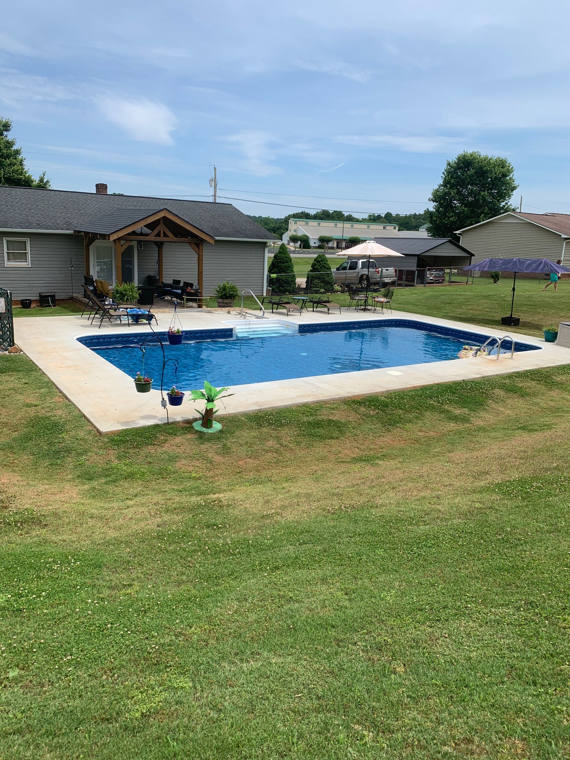 There is a large swimming pool in the backyard of a house.