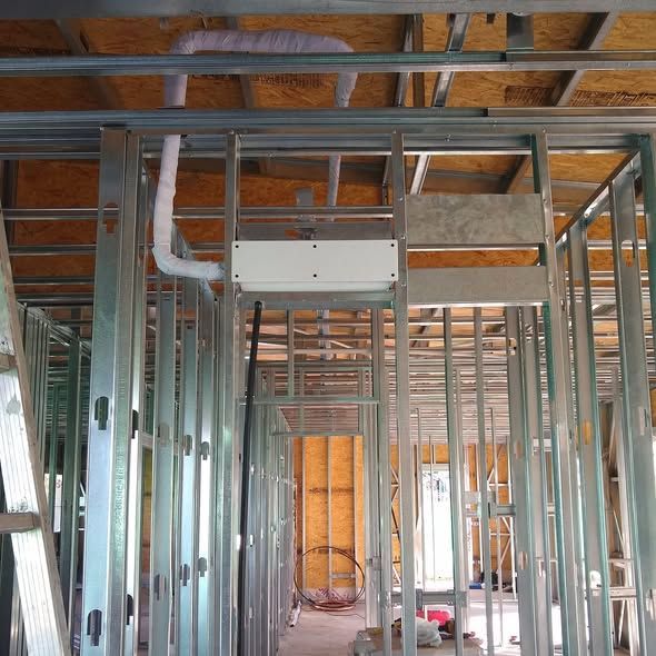 Vista interior de la estructura de un edificio en construcción. Se aprecian los montantes metálicos y los conductos.