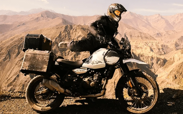Motorcyclist on a white adventure bike overlooking a rocky desert landscape