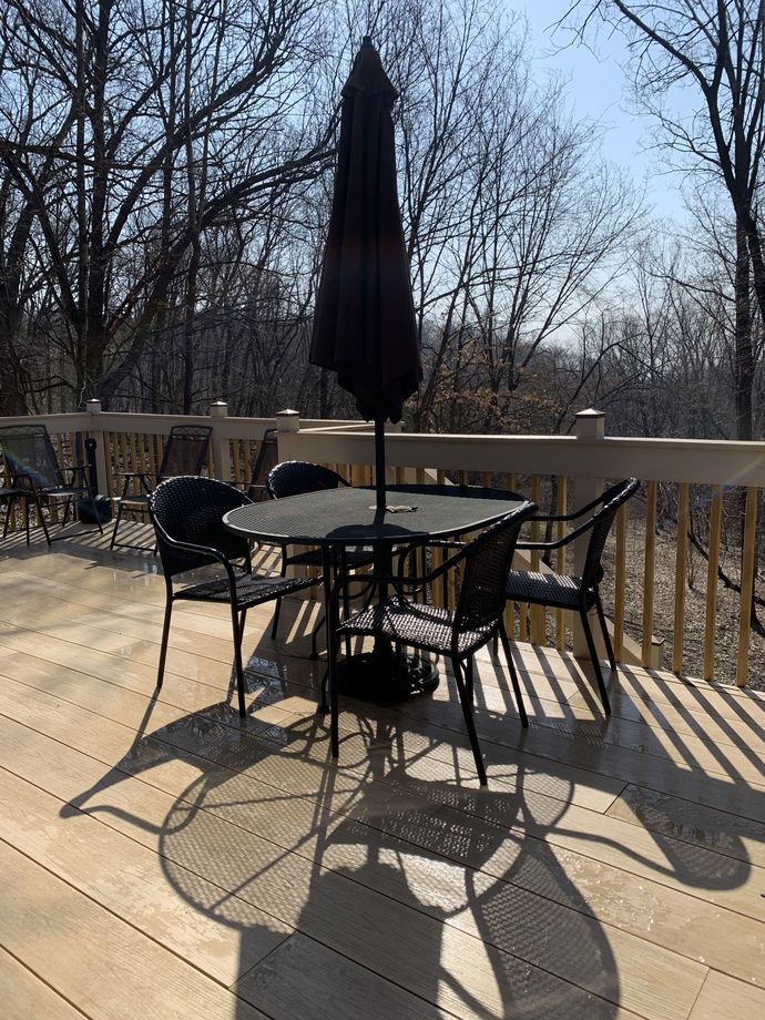 Outdoor table and chairs with umbrella on a wooden deck.