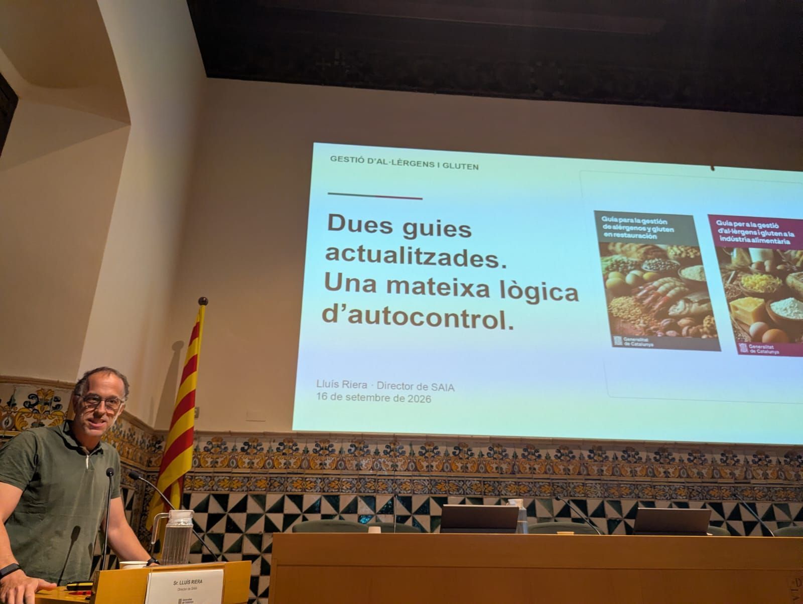 Speaker beside projected slide on duck feeding and self-control, in a lecture hall