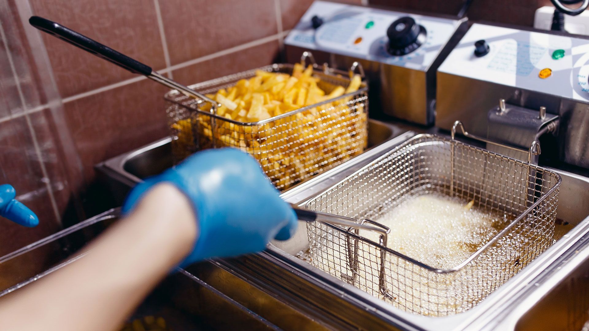Una persona está cocinando papas fritas en una freidora.