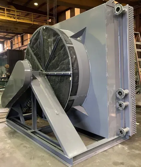 Large industrial fan with silver housing and black blades in a factory setting
