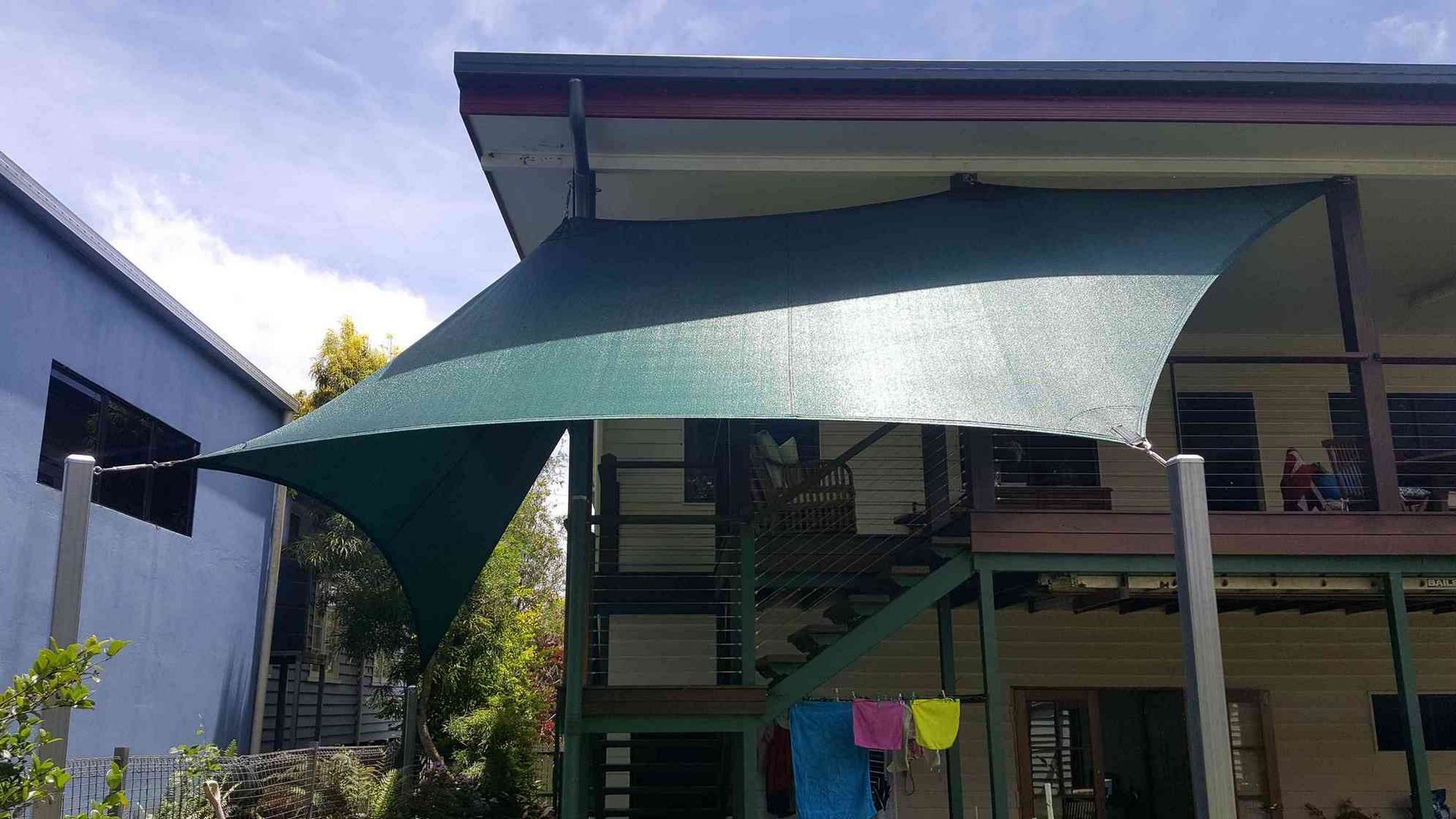 A Large Green Umbrella is Sitting in Front of a House — Style Shades Installation In Dimbulah, QLD