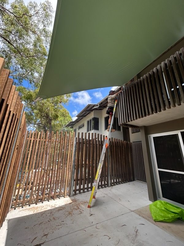 A Pink Umbrella Is Hanging From The Roof Of A House — Style Shades Installation In Edmonton, QLD